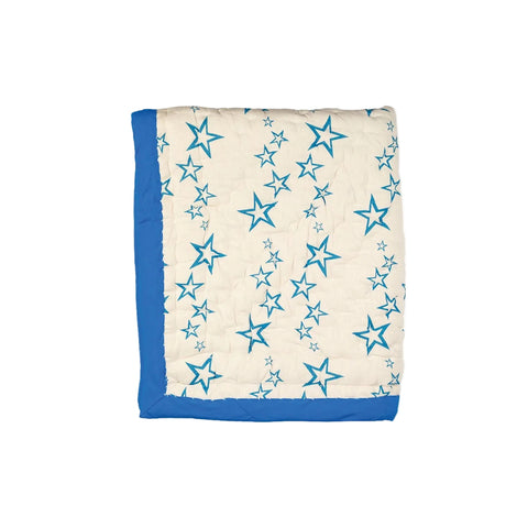 A folded Nepali single quilt with blue stars on a cream background, bordered with a blue cotton edge.
