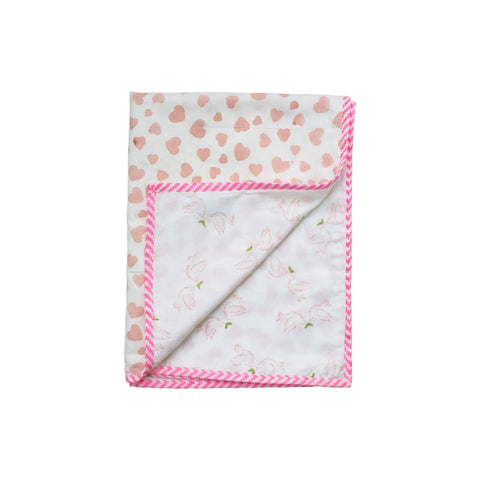 A reversible baby blanket with one side featuring a pink heart print and the other side dove print, both on a white background, with a pink decorative border.