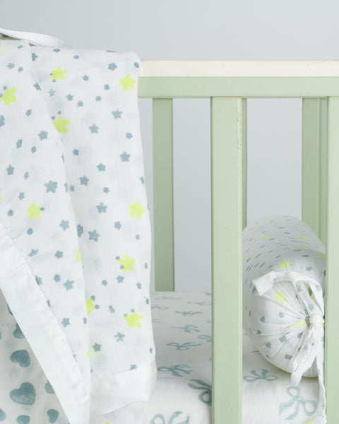 reversible muslin blanket trimmed in white satin with blue and neon yellow star and heart block prints