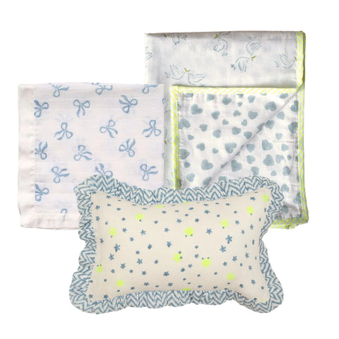 A cotton baby blanket, muslin square and mini ruffle pillow with block printed designs on a white background