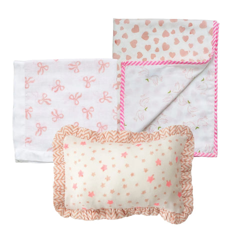 A cotton baby blanket, muslin square and mini ruffle pillow with block printed designs on a white background