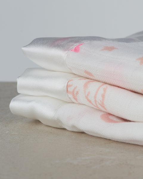 close up of pink muslin trio with satin trim