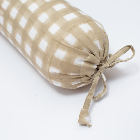 taupe and white checkered cylindrical pillow with a tie on a white background